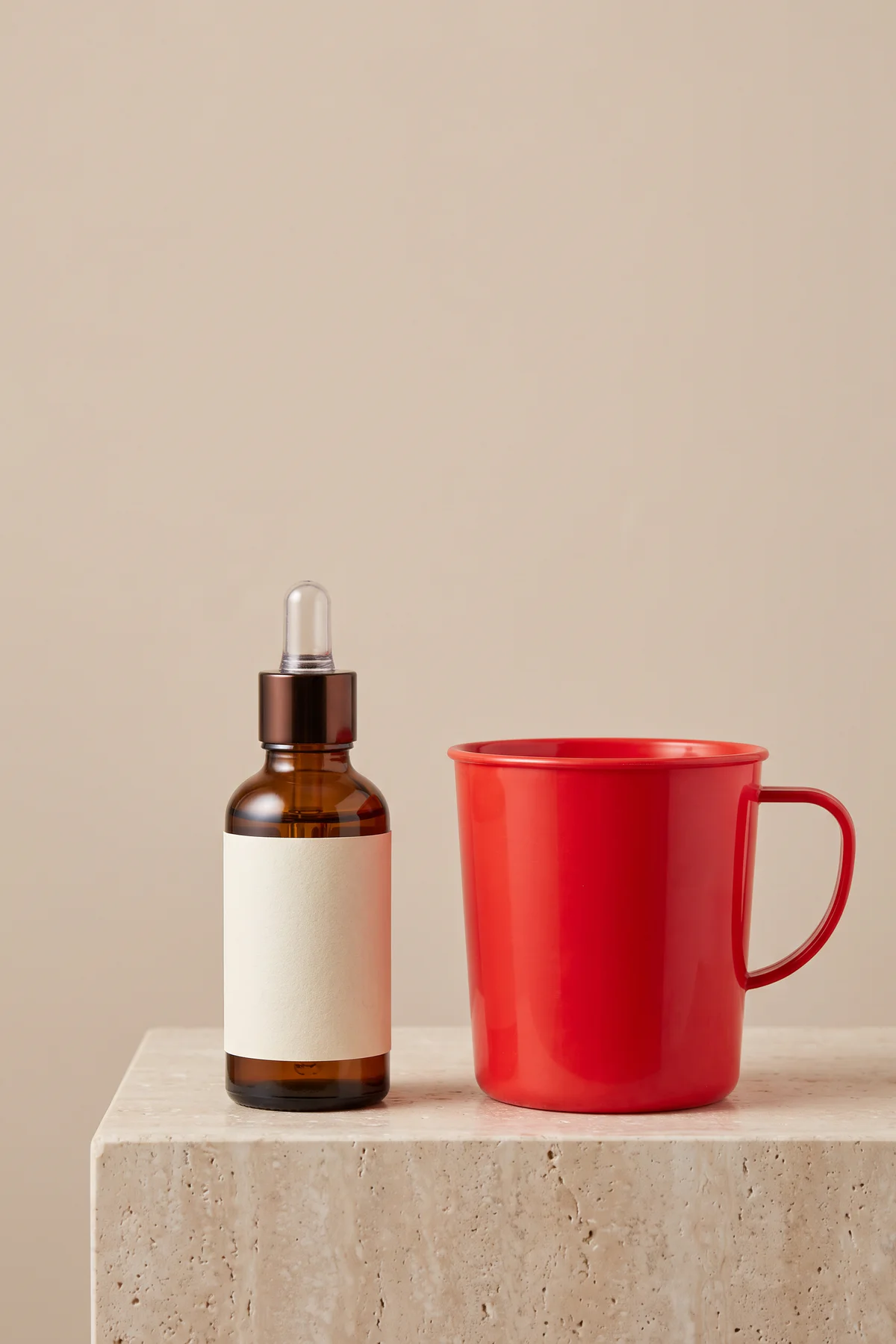Amber serum bottle beside a red plastic mug before AI prop replacement